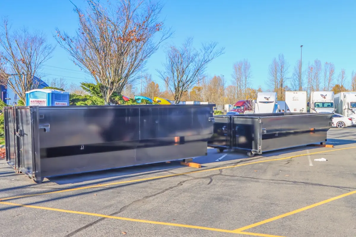 Professional dumpster rental service with roll-off container on residential driveway in Rainsville